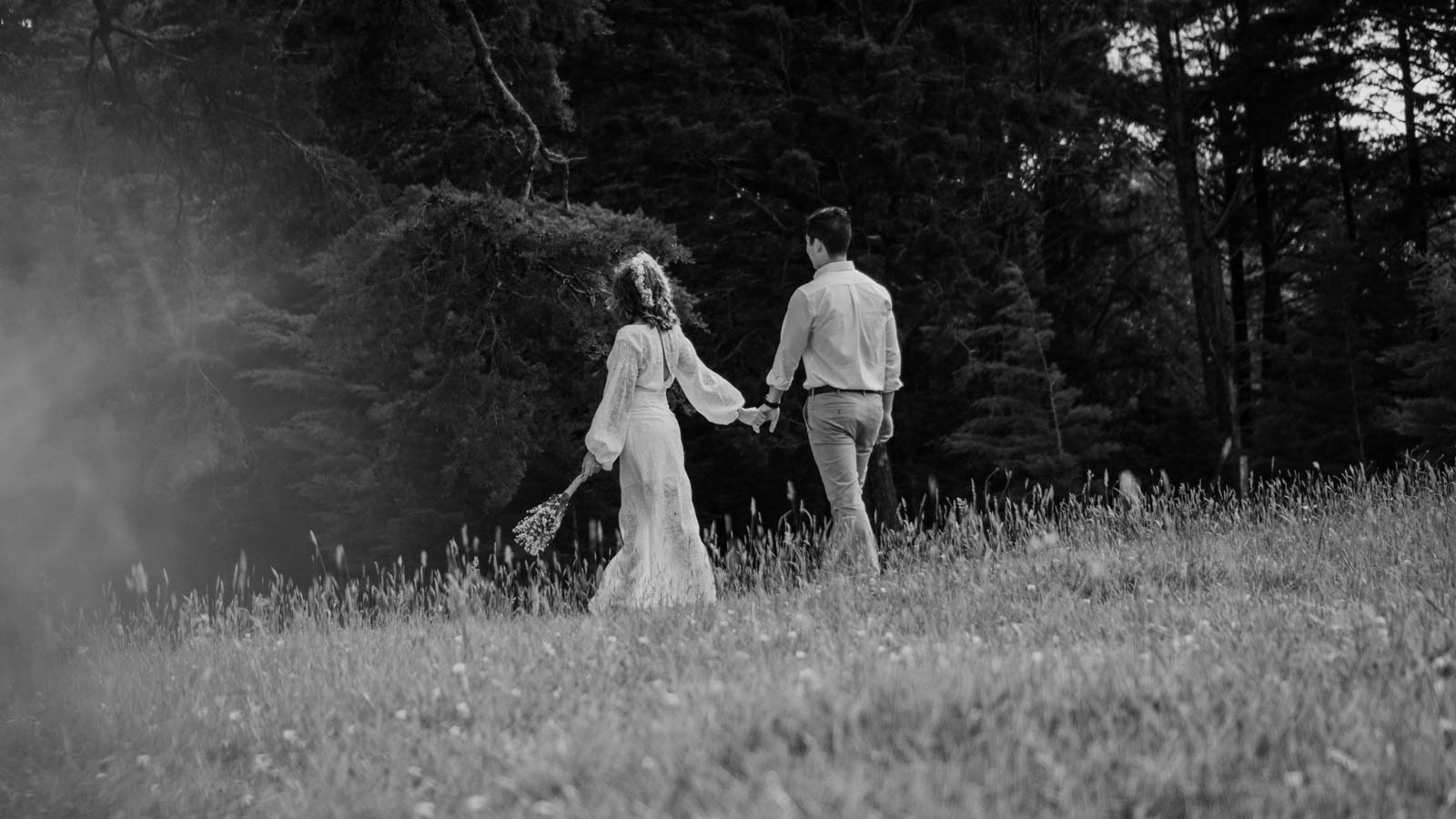 Black and white photo of a married couple walking down a mountain during their wedding photography shoot, captured by Lov Films.