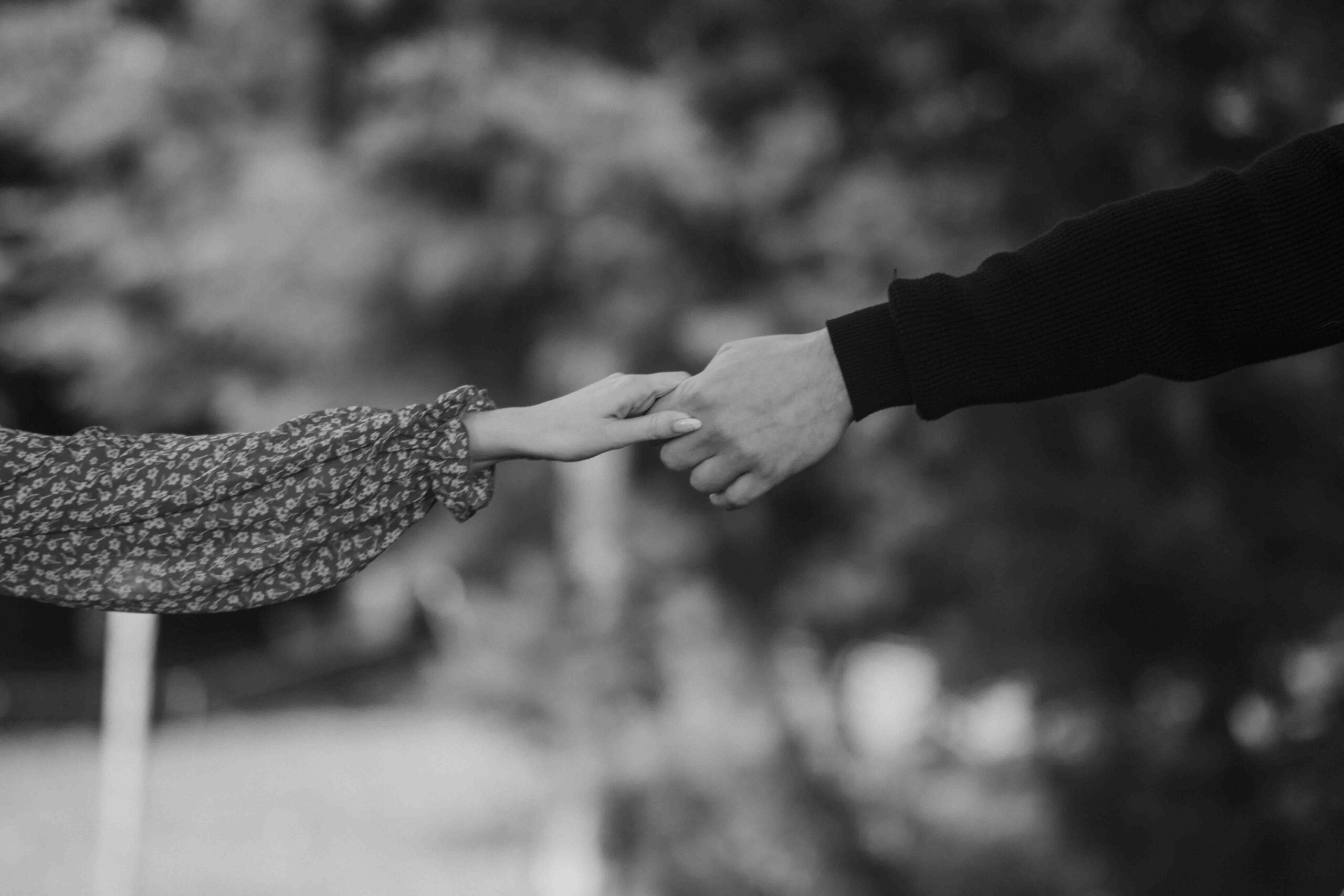 Black and white photo of an engaged couple's arms and hands in a romantic pose, captured by Lov Films